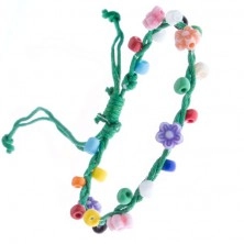 Zöld színű kötött karkötő madzagokból, színes virágokkal