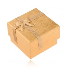 Aranyozott dobozka gyűrűre szalaggal díszítve, arany színű rózsa