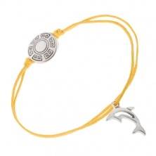 Sárga zsinóros karkötő, kerek tábla görög kulcs mintával, delfin
